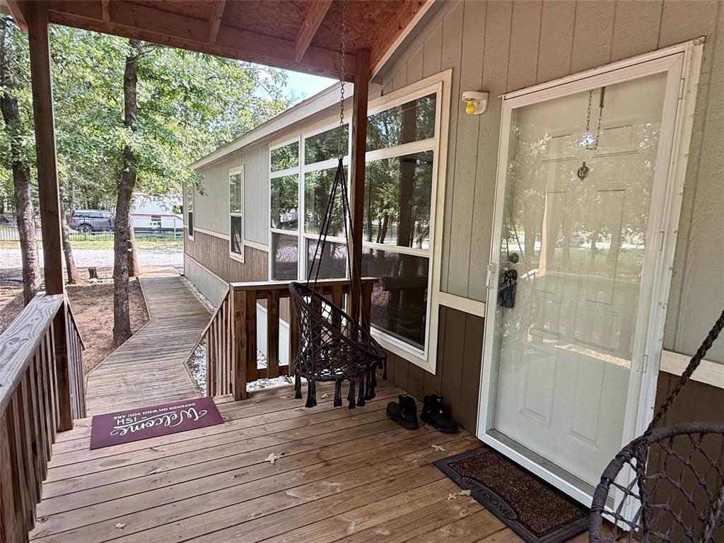 145 Adalida Lane Springtown, TX 76082 - Photo 4 of 29 Expansive wood-finish deck with a built-in ramp, white entry door, and large windows