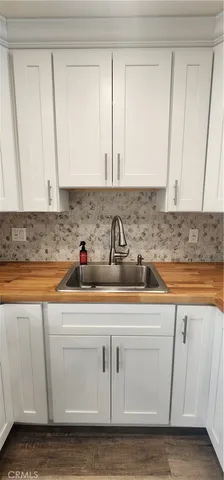 a kitchen with white cabinets sink and dishwasher