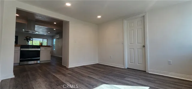 a view of a hallway with wooden floor and a living room