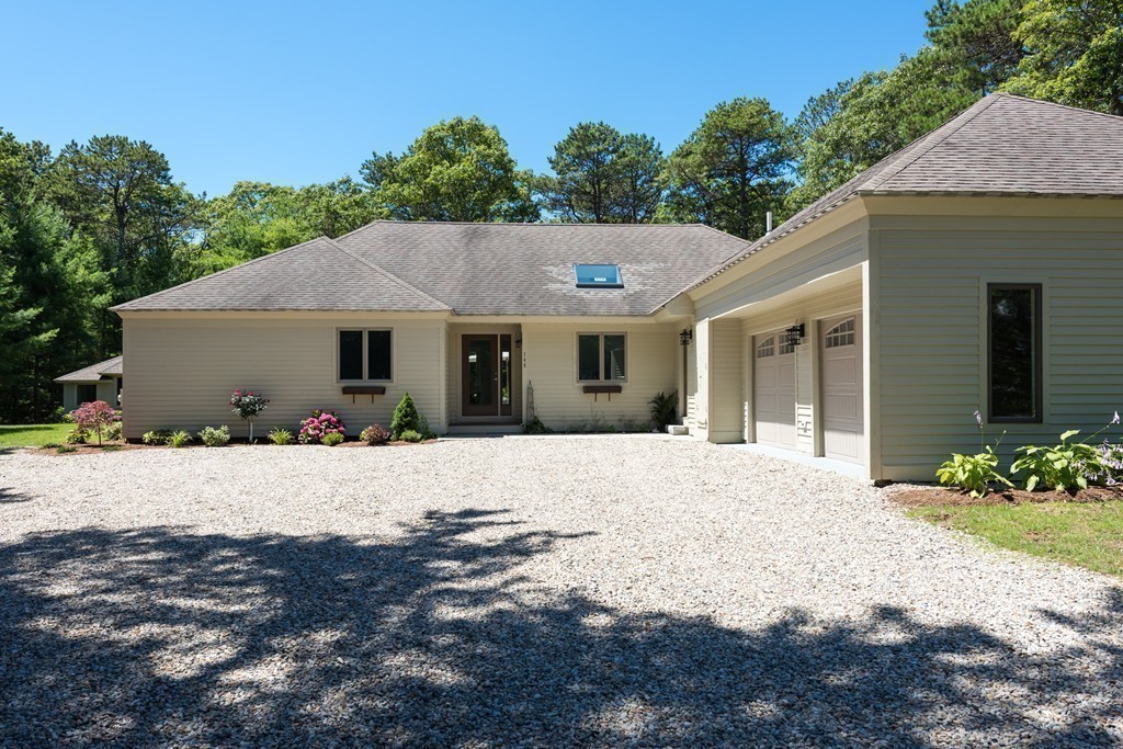 148 Paddock Circle Mashpee, MA 02649 - Photo 20 of 28 a front view of a house with a yard and garage