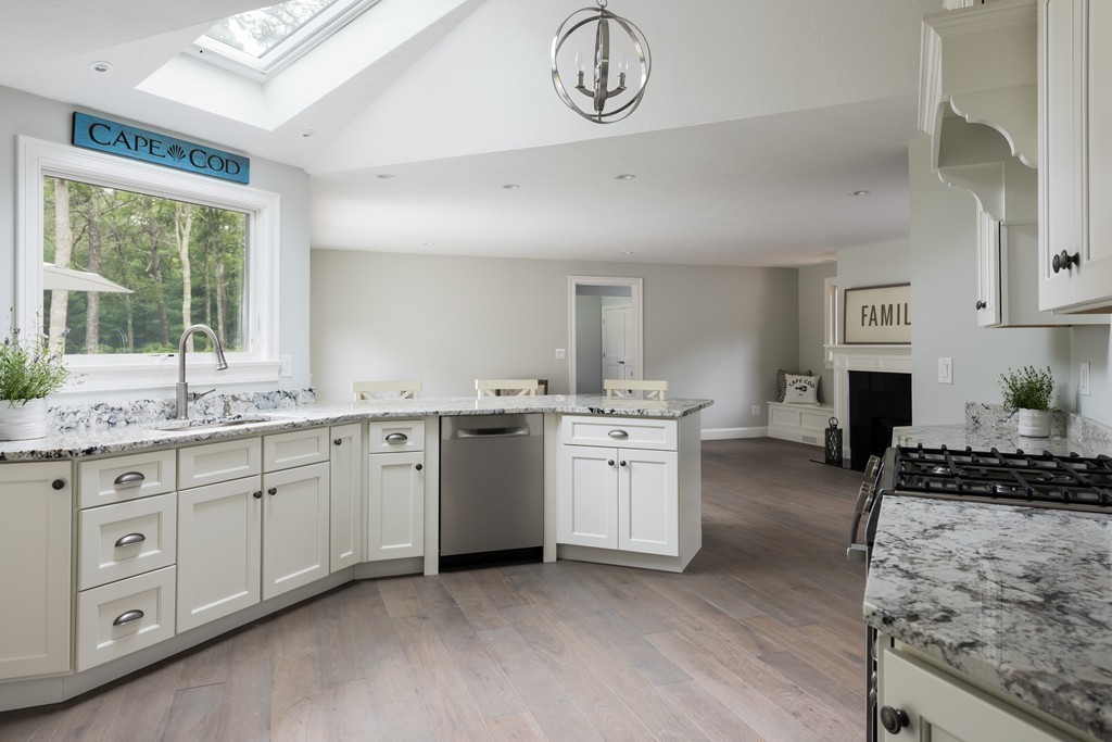 148 Paddock Circle Mashpee, MA 02649 - Photo 4 of 28 a open kitchen with cabinets a stove a sink and a large window