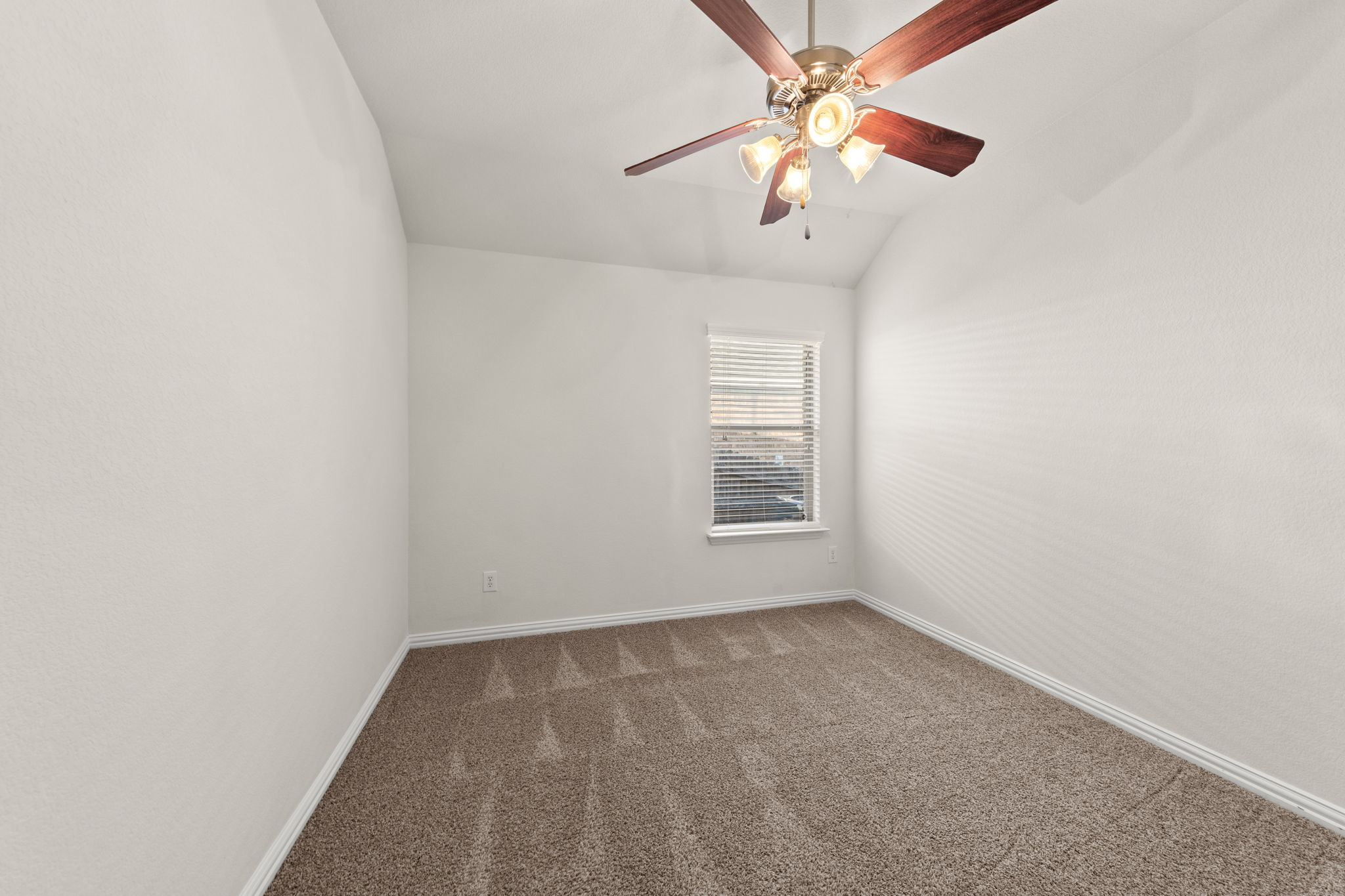 411 Tascate Street Georgetown, TX 78628 - Photo 35 of 41 A comfortable bedroom features plush carpeting and a vaulted ceiling with a classic ceiling fan.