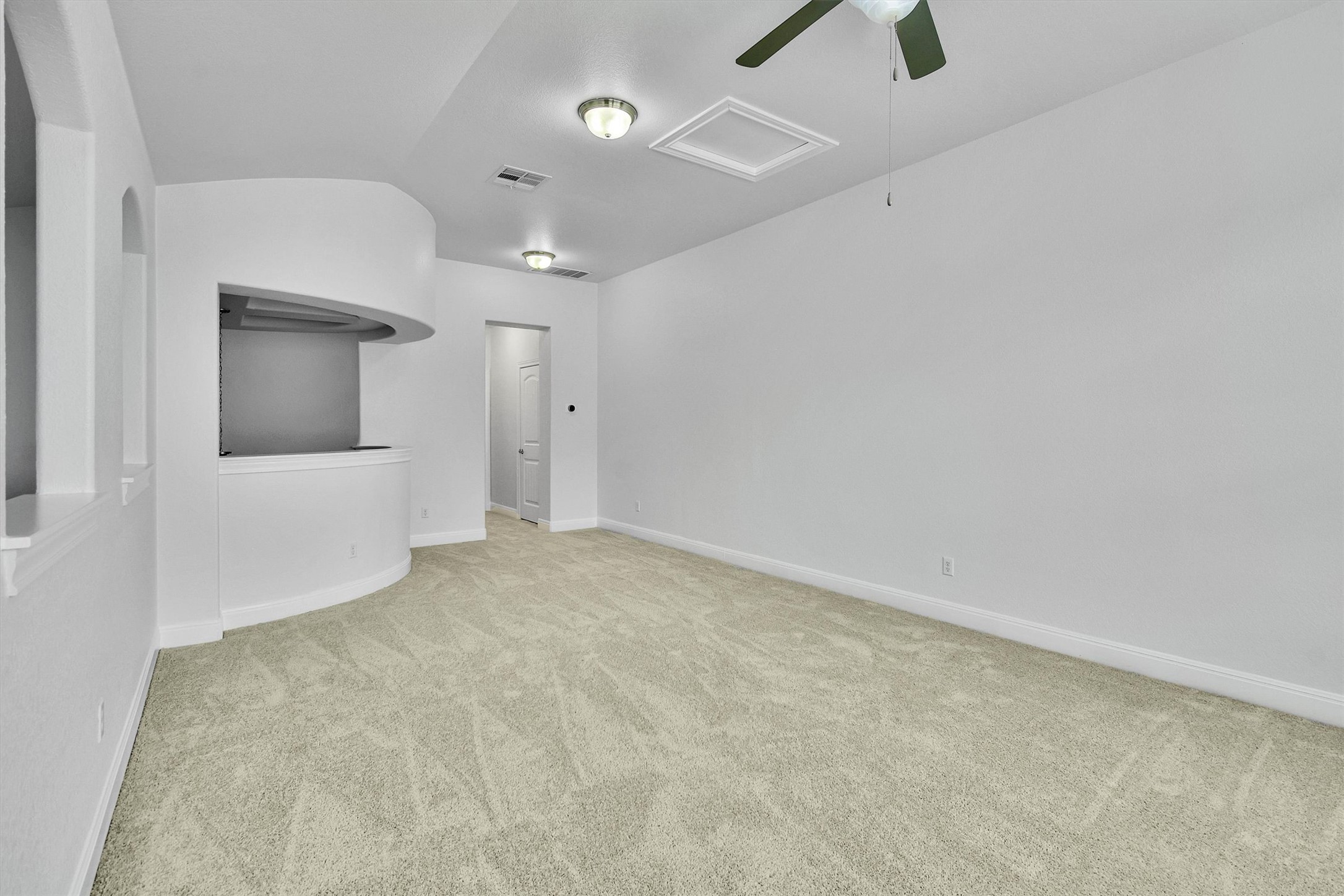 2325 Blended Tree Ranch Drive Leander, TX 78641 - Photo 28 of 35 A spacious common area with plush carpeting and an architectural half-wall, perfect for gathering.