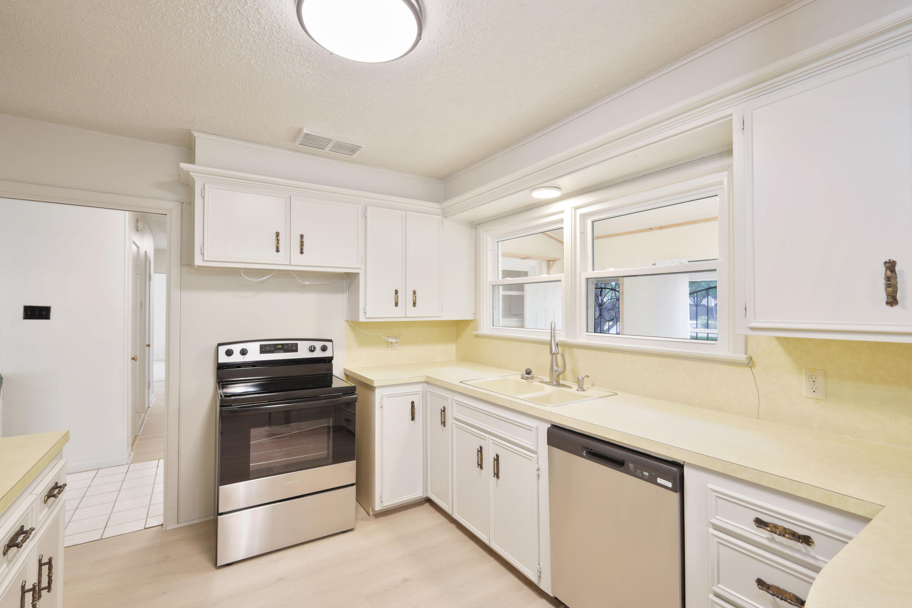 3202 45th Street Lubbock, TX 79413 - Photo 5 of 20 a kitchen with white cabinets and white appliances
