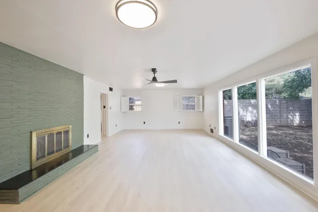 a view of a livingroom with wooden floor and a large window