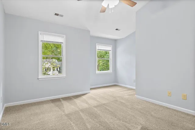 a view of an empty room with a chandelier fan