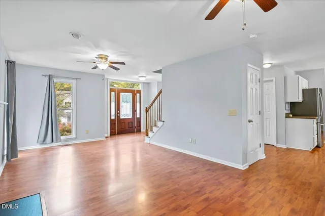a view of an empty room with window and fire place