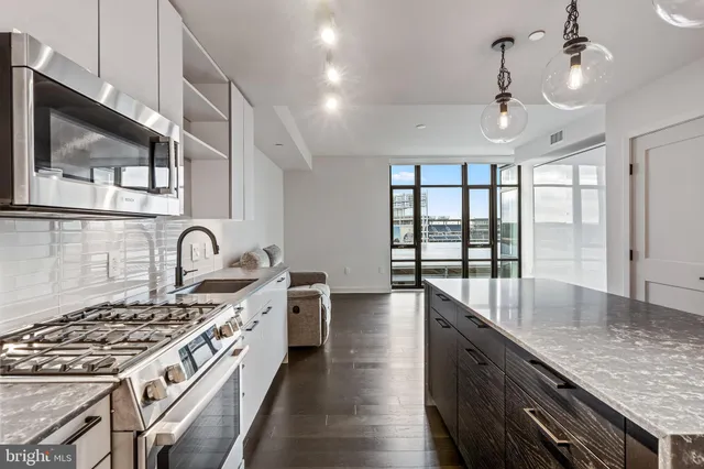 a open kitchen with stainless steel appliances granite countertop a stove and a sink