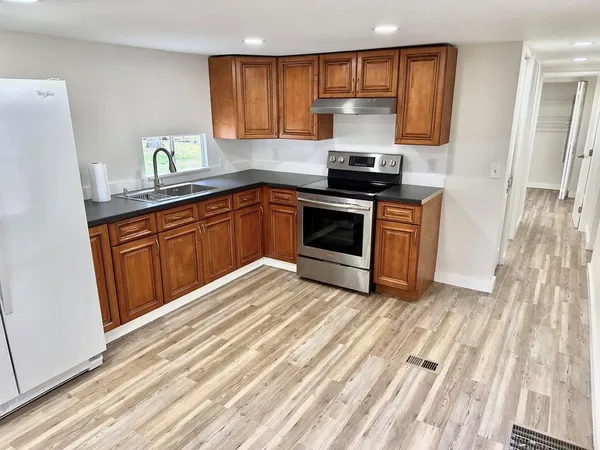 a kitchen with stainless steel appliances granite countertop a stove a sink and a refrigerator
