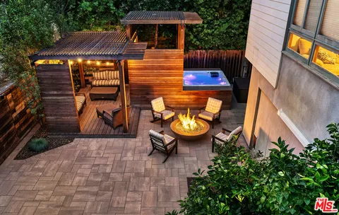 a view of a patio with table and chairs potted plants and wooden fence