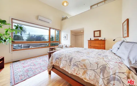 a bedroom with a bed and a large window