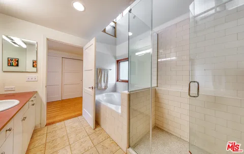 a bathroom with a tub sink and mirror