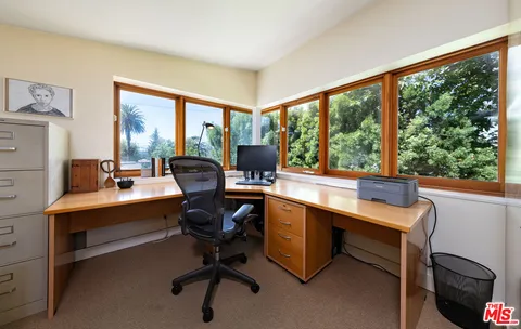 a view of a workspace with furniture and a window