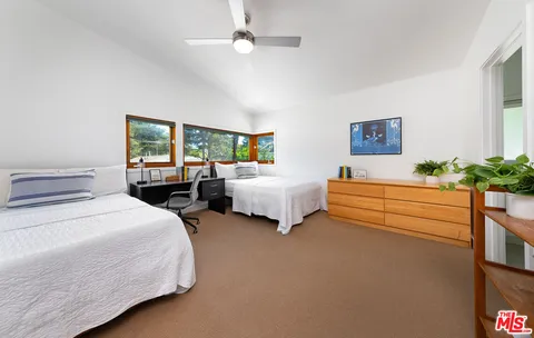 a bedroom with bed and a large window