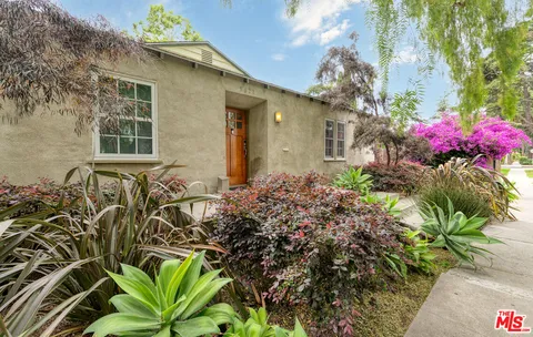 a front view of a house with a lot of flower plants