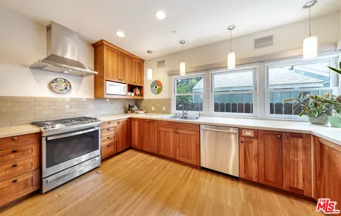 a large kitchen with stainless steel appliances granite countertop a stove a sink and a refrigerator