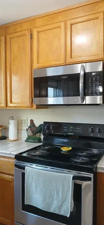 a kitchen with granite countertop a stove and a microwave