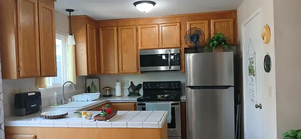 a kitchen with stainless steel appliances granite countertop a refrigerator and a sink