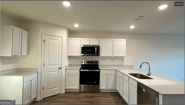 a kitchen with a sink and white cabinets