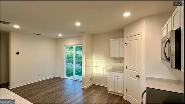 a view of hallway with wooden floor and electronic appliances