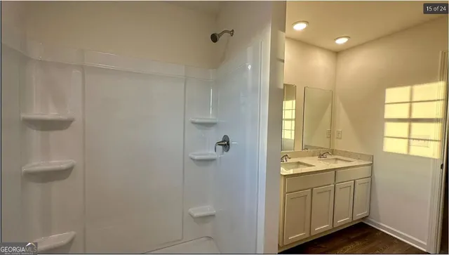 a bathroom with a granite countertop sink a shower and a mirror