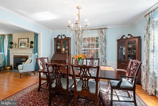 a dining room with furniture a chandelier and wooden floor