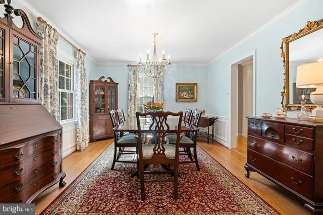 a dining room with furniture a chandelier and wooden floor