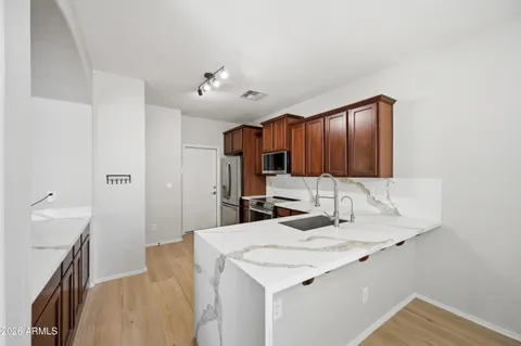a kitchen with kitchen island granite countertop a sink and refrigerator