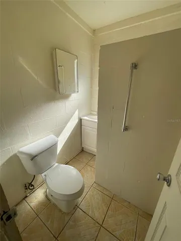 a white toilet sitting next to a bathroom sink and a mirror