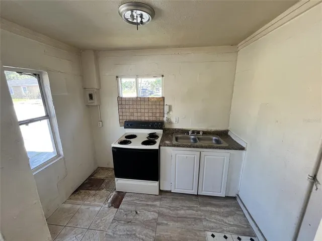 a kitchen with granite countertop a stove and a sink