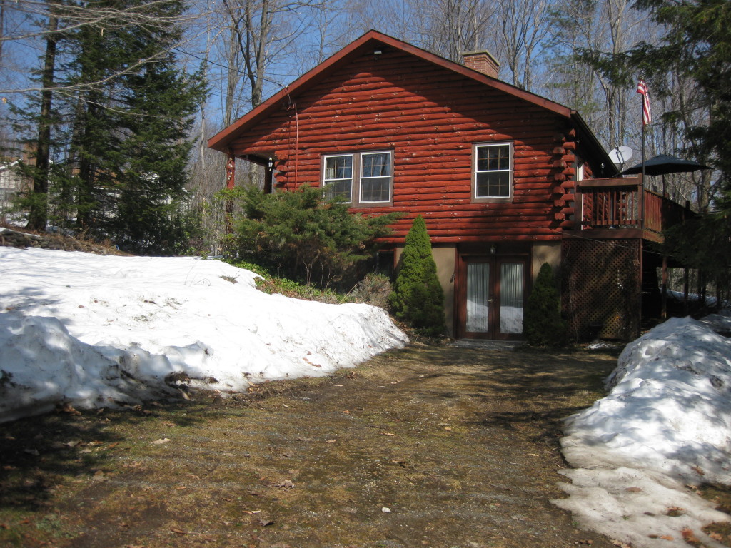 162 Chipman Road Middlefield, MA 01011 - Photo 2 of 11 a front view of a house with a yard covered in snow