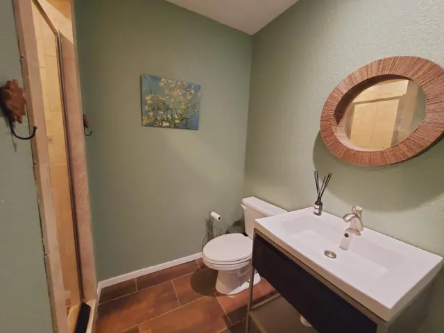 a bathroom with a sink a toilet and a mirror