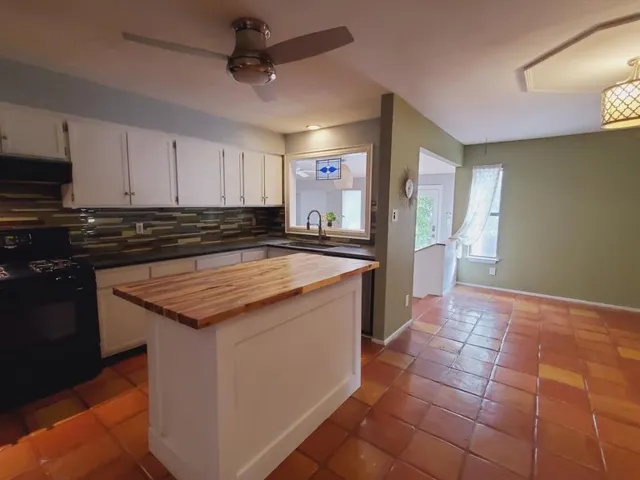 a kitchen with a sink a counter top space cabinets and stainless steel appliances
