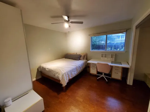 a bedroom with a bed and a table chair