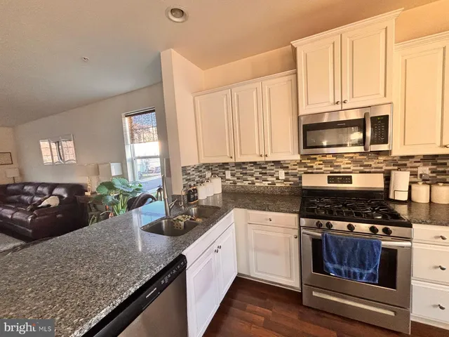 a kitchen with sink a microwave and cabinets
