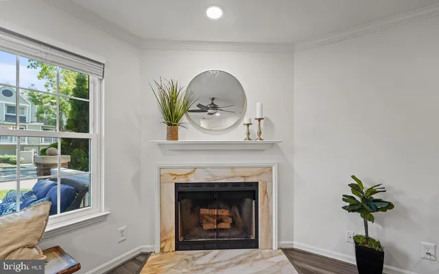 a living room with a fireplace and potted plants