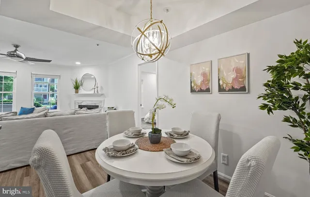 a view of a dining room with furniture a chandelier and wooden floor