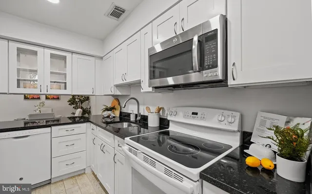 a kitchen with stainless steel appliances a stove a microwave a sink and cabinets