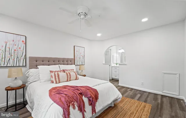 a spacious bedroom with a bed and wooden floor