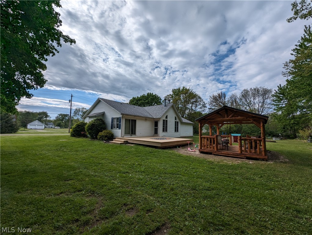 7272 Poore Road Conneaut, OH 44030 - Photo 8 of 26 Back of house with a deck, a gazebo, and a lawn