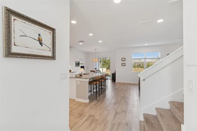 a kitchen with stainless steel appliances kitchen island granite countertop a dining table chairs and granite counter tops