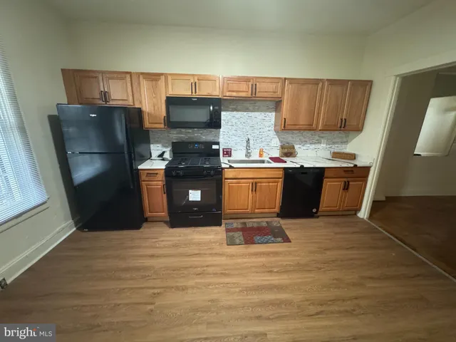 a kitchen with stainless steel appliances wooden cabinets a stove top oven a sink and dishwasher