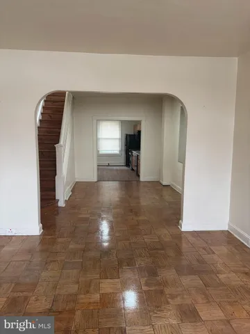 a view of a hallway with wooden floor and chandelier