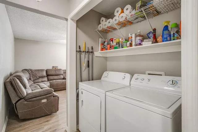 a utility room with dryer washer and a view of living room