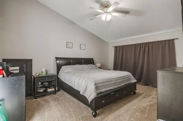 a spacious bedroom with a bed and a chandelier