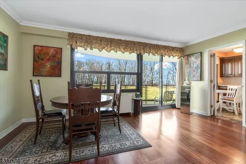 a view of a dining room with furniture water view and wooden floor