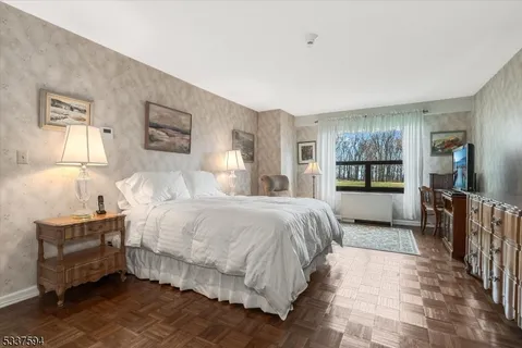 a bedroom with a bed and a large mirror on the dresser