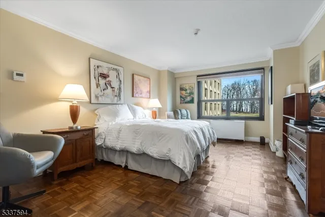 a bedroom with a bed couch tv and a window