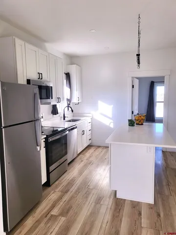 a kitchen with stainless steel appliances a stove a sink and a refrigerator