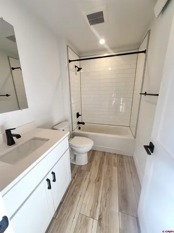a view of a room with wooden floor and white walls